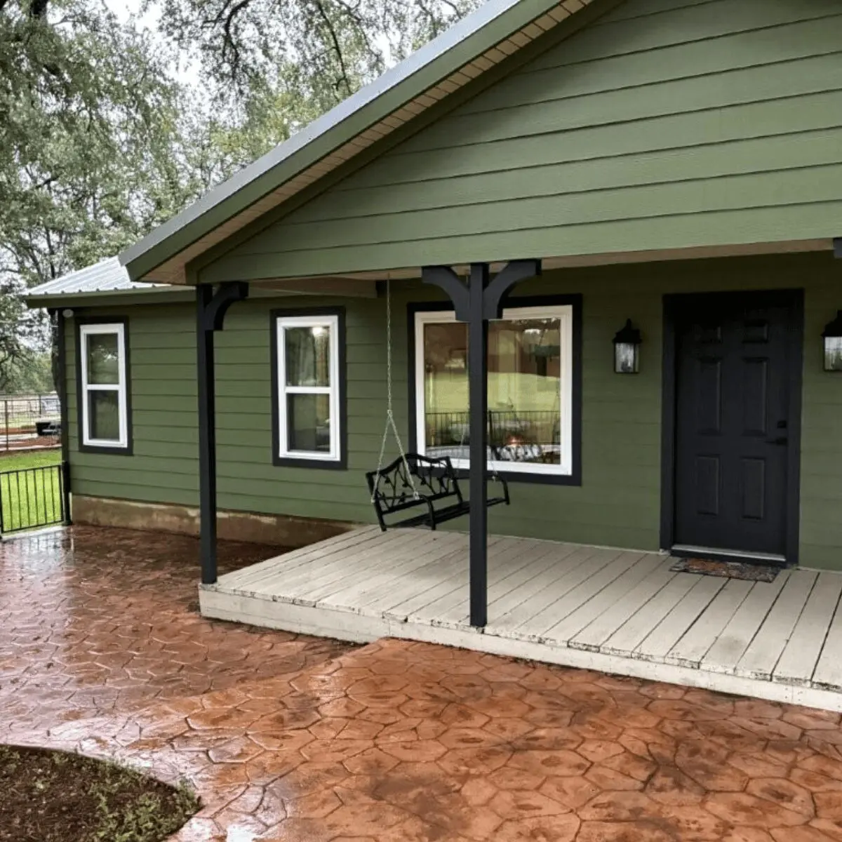 White double-hung replacement windows installed by Allied Exteriors on a green-sided home in Bertram, Texas.