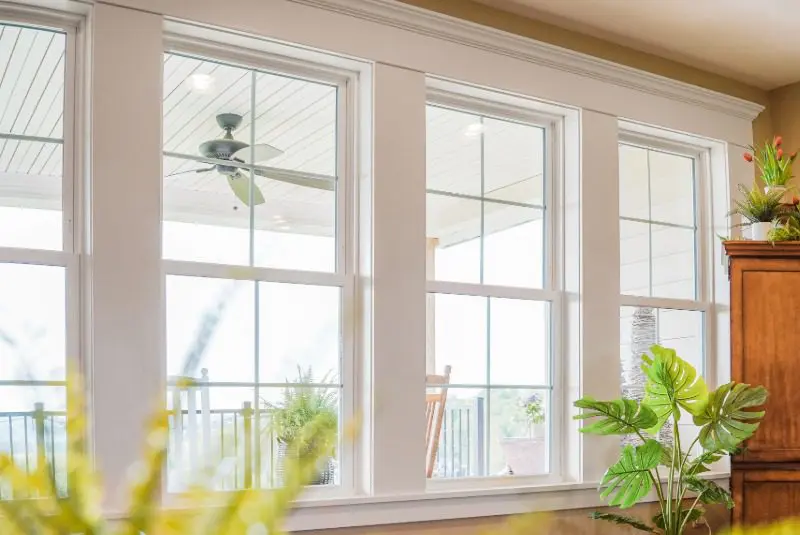 Four double-hung white windows with internal grids in a bright living room