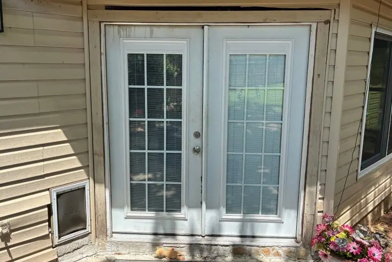Warped patio door with visible staining and moisture damage near the bottom.