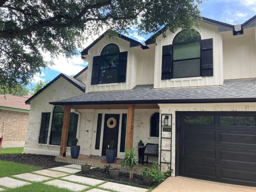 James Hardie® board-and-batten siding on a two-story home with black shutters and a black garage door.