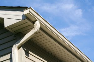 Close-up shot of the corner of a home with a gutter and downspout