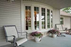 Beige front porch with a bow window with grids