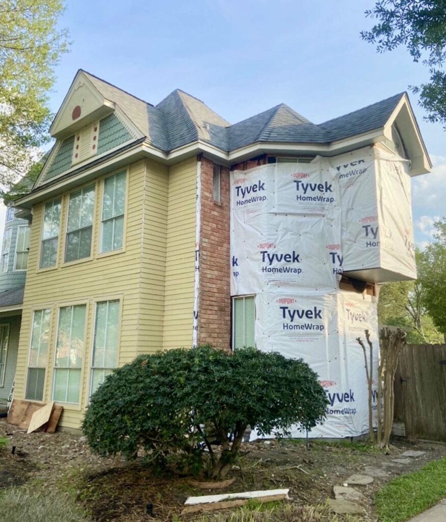 Two story home with house wrap on one side before getting siding replaced