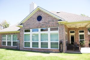Back of a brick home with 8 white vinyl double hung windows