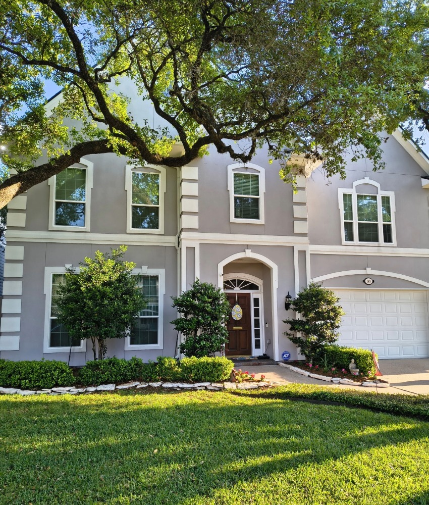 Facade of grey home with double hung white windows