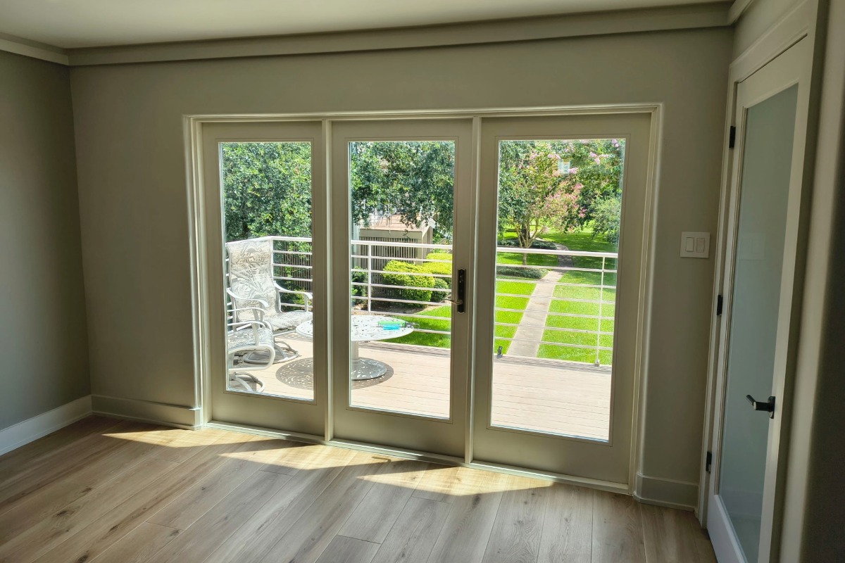 three-panel steel hinged patio door looking out to a yard