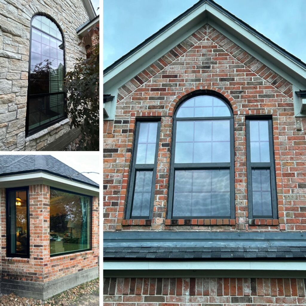 Black replacement windows with a tall arched specialty window installed by Allied Exteriors on a brick home in Montgomery, Texas.