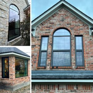 Black replacement windows with a tall arched specialty window installed by Allied Exteriors on a brick home in Montgomery, Texas.