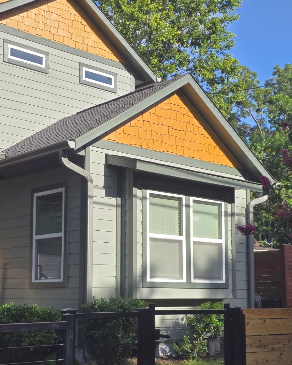 Front of home with lap and shingle siding with grey gutters