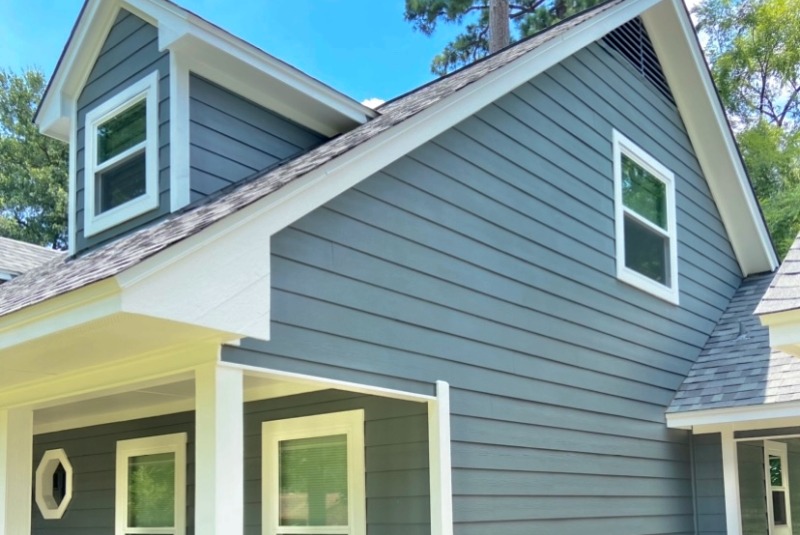 Side of home with grey-blue lap siding and white trim windows