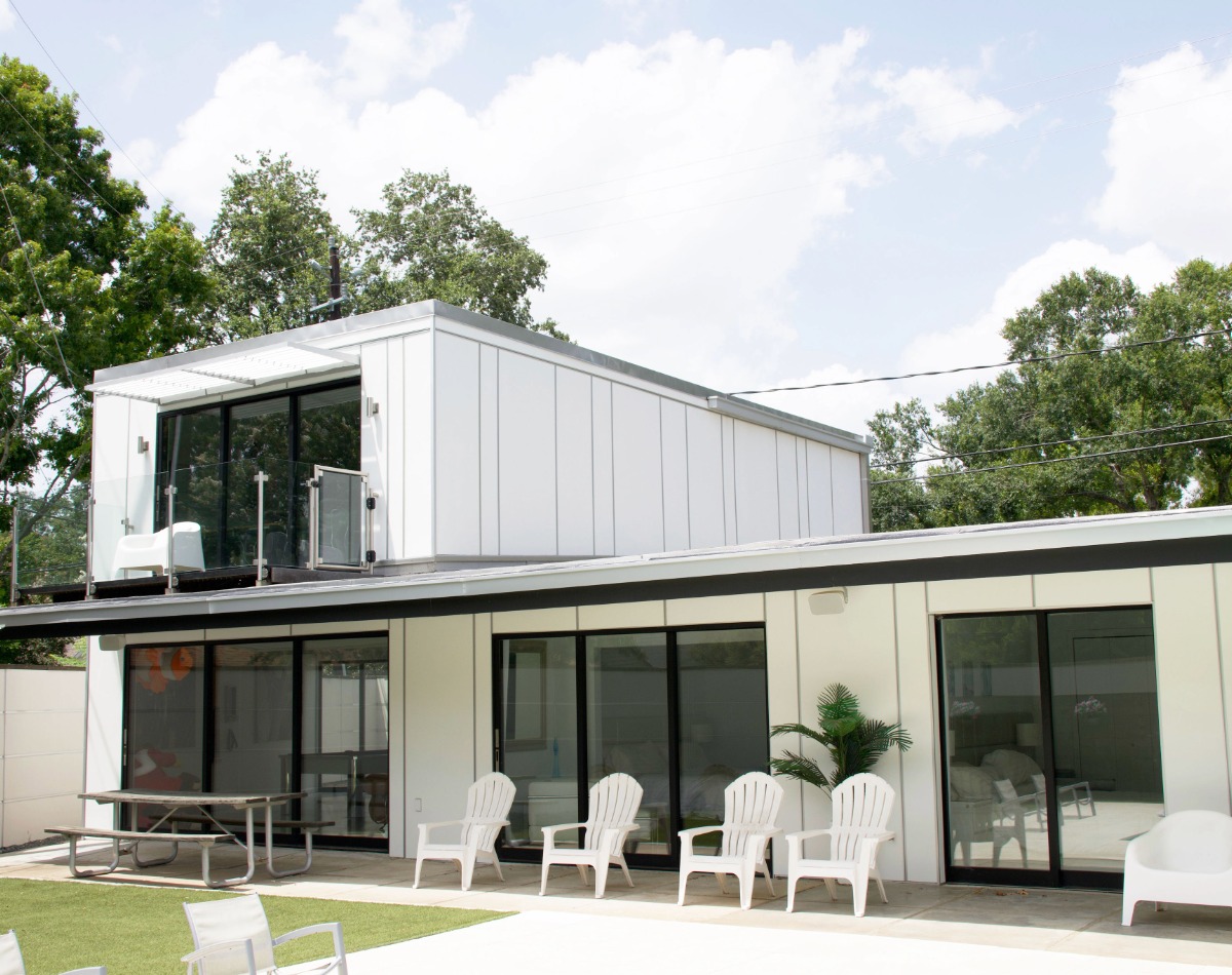 Hardie panel siding on home with black accent and oversided windows