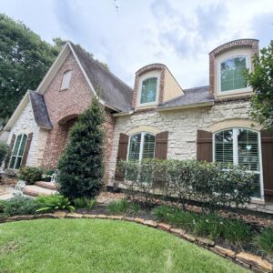 White replacement windows with arched specialty windows installed by Allied Exteriors on a brick home in Tomball, Texas.