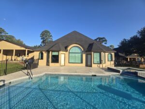 Bronze replacement windows with an arched specialty window installed by Allied Exteriors on the back of a home with a pool in Willis, Texas.