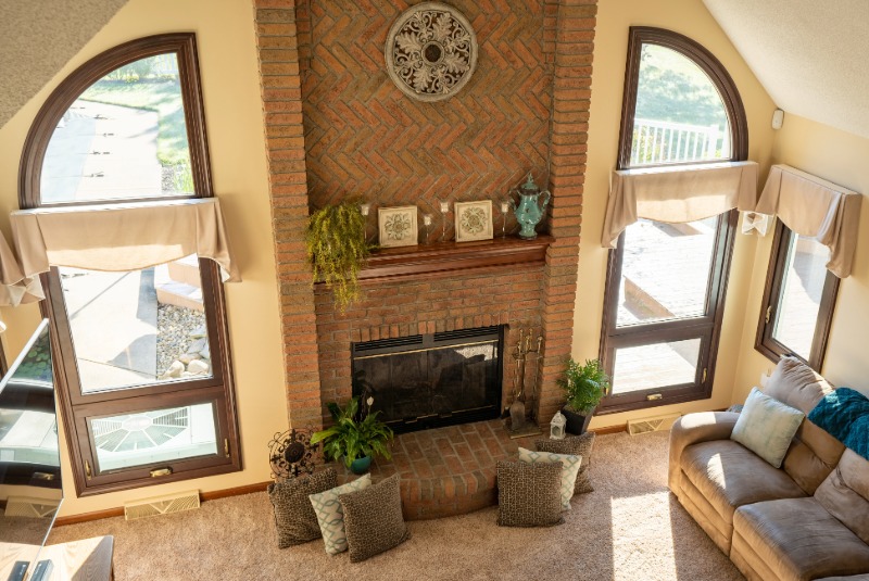 Living room with two speciality shaped wood interior windows from floor to ceiling